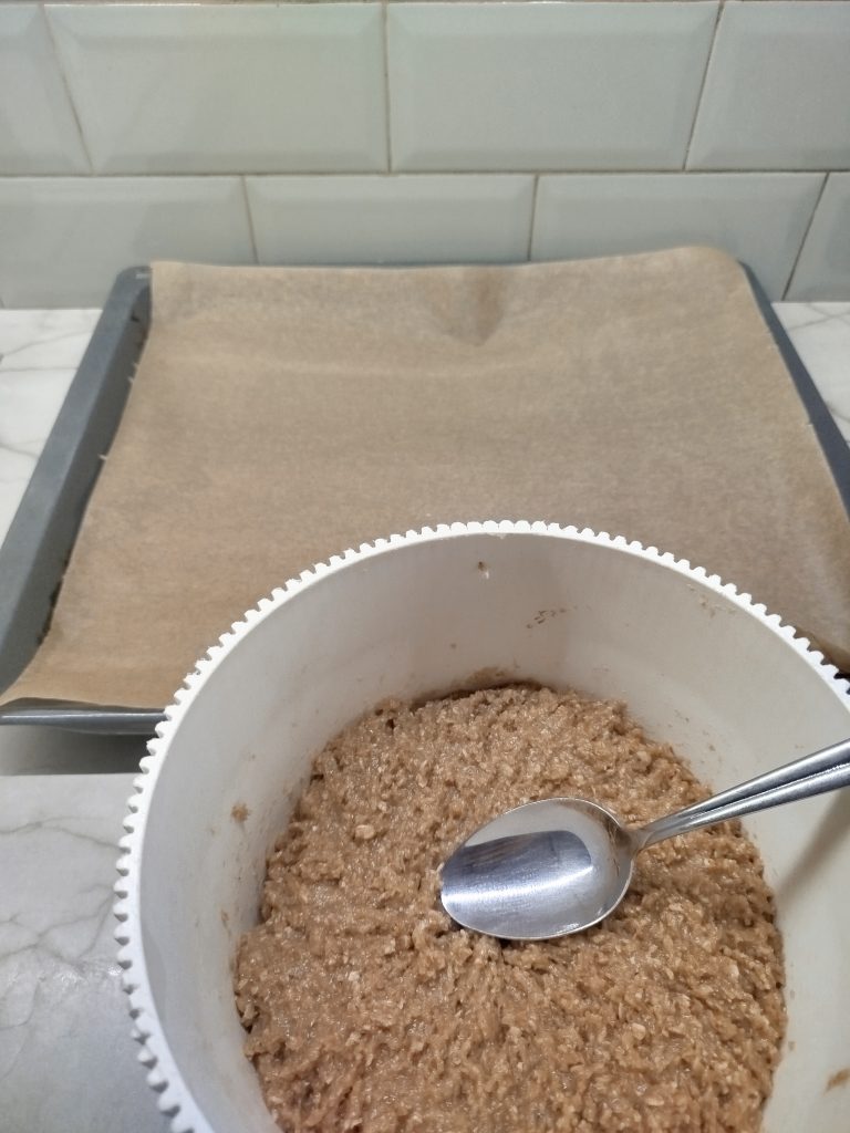 spreading oatmeal cookie dough onto a baking sheet